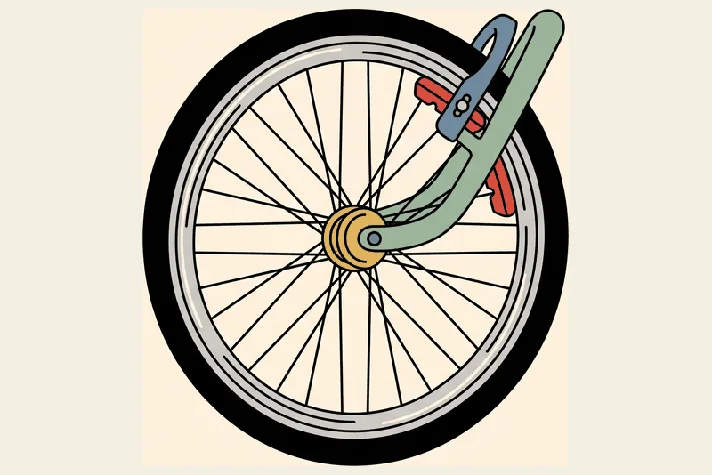 A bicycle wheel with two brake blocks clamped onto the metal rim.